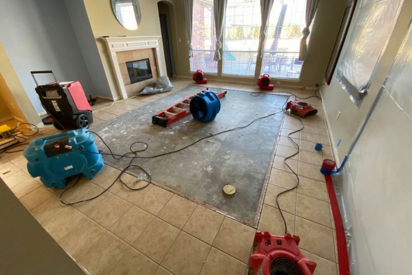 A team repairing water damage on the floor in a room, representing a restoration service in Los Angeles, CA.